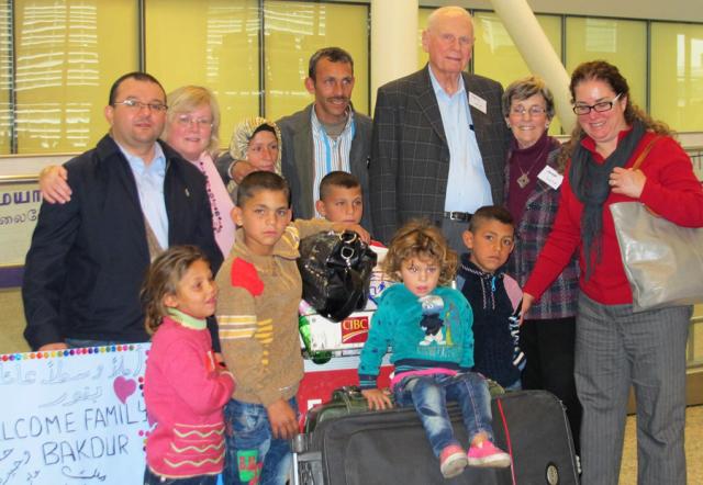 A refugee family from Syria is welcomed at the airport by their sponsors