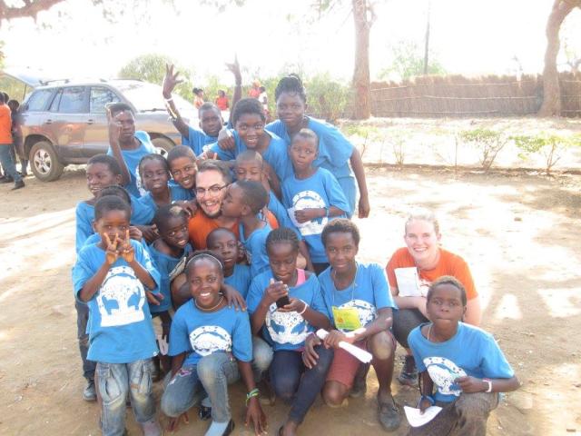 Emmanuel United counsellors Brett and Carla are warmly embraced by children at Camp Chipembi in 2015. A group of children surround two Canadian visitors to Zambia for a photo.