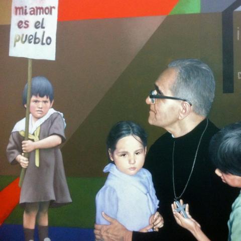 A detail from a mural at Monseñor Óscar Arnulfo Romero International Airport in El Salvador, showing Archbishop Oscar Romero and several children, one holding a sign that says "Mi amor es el pueblo" ("My love is the people.")