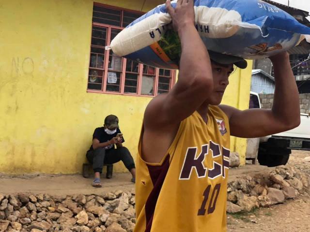 The Serve the People Brigade of the Cordillera Disaster Response Network distributes rice to people in need.