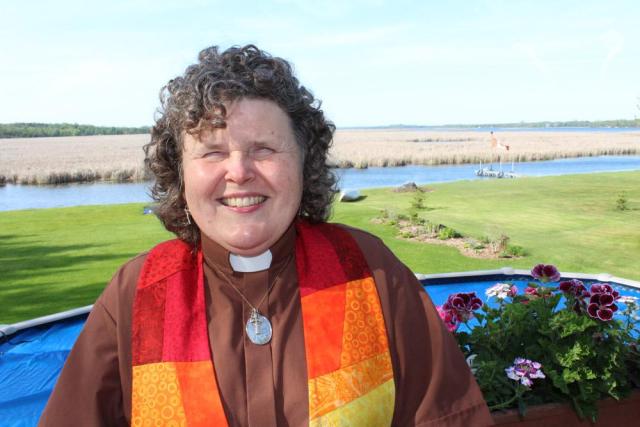 Sharon Ballantyne wearing a colourful minister's stole across her shoulders. Sharon Ballantyne is ministry personnel, serving a rural pastoral charge about two hours northeast of Toronto. A 2018 McGeachy Senior scholar, her work is focusing on equity. 