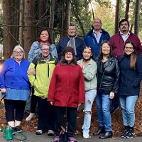 Ten people from the Indigenous Ministries and Justice staff gather for a photo in the British Columbia forest.