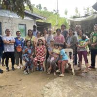 A large group of village residents stand with Moderator Carmen Lansdowne and Rev. Dr. Japhet Ndhlovu in a Filipino mountain village.