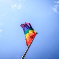 The rainbow-coloured pride flag flies against a blue sky
