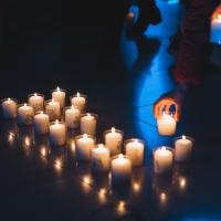 A row of lit votive candles in a church