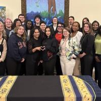 Large group of young people pose in front of Canadian Foodgrains Bank banner