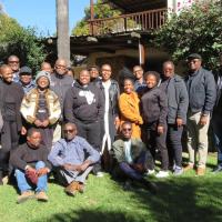 A group of about 25 participants gathered outside in the morning sun.