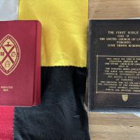 The United Church Mohawk Bible lies on a black, yellow, white, and red flag, next to the former Union Bible.