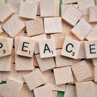 Scrabble letter tiles spelling out "Peace"