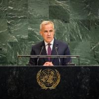 Prime Minister Mark Carney speaks at a podium at the United Nations