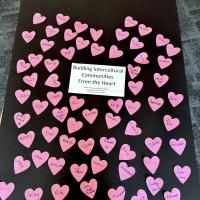 A poster filled with pink hearts, each with a name written on them