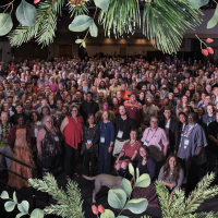 A large group photo with a Christmas wreath overlaid