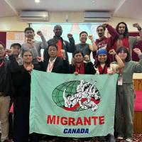 A group of people with fists raised and a sign that reads "Migrante Canada"