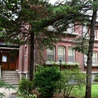 A large red-brick house behind trees