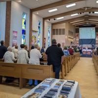 A photo of a church interior full of standing members