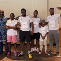 A group of boys and men pose in athletic clothes, with the word "Haiti" on their shirts