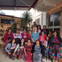 A group of smiling women outdoors in colourful clothing