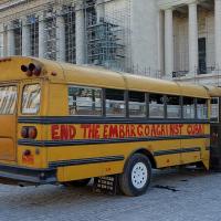 A school bus in Havana with graffiti painted on it that says "End the embargo against Cuba!"