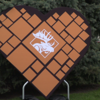 A large sign in the shape of a heart with a white moose icon in the middle