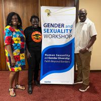 Three smiling adults stand near a poster that says "Faith Beyond Borders" and "Gender and Sexuality Workshop"