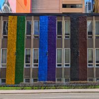 An exterior church wall painted in rainbow colours