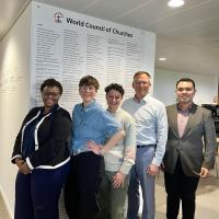 A group of people pose in front of a wall that reads "World Council of Churches"