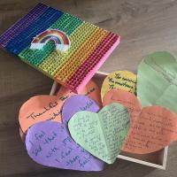 Rainbow hearts made of paper with writing on them